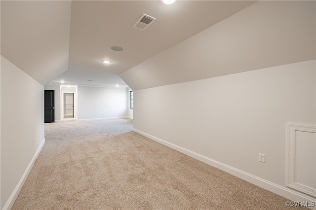 additional living space featuring lofted ceiling and light carpet