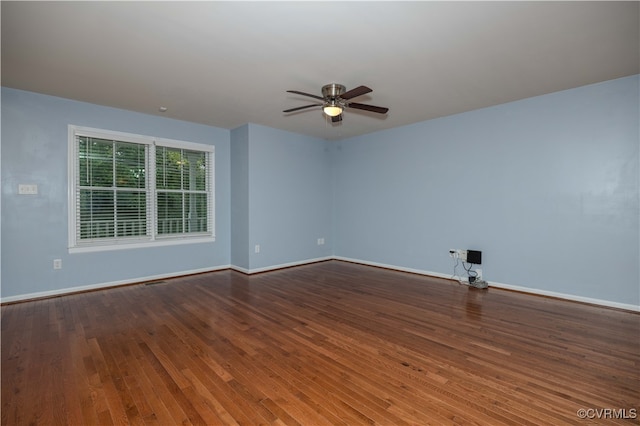 empty room with dark hardwood / wood-style flooring and ceiling fan