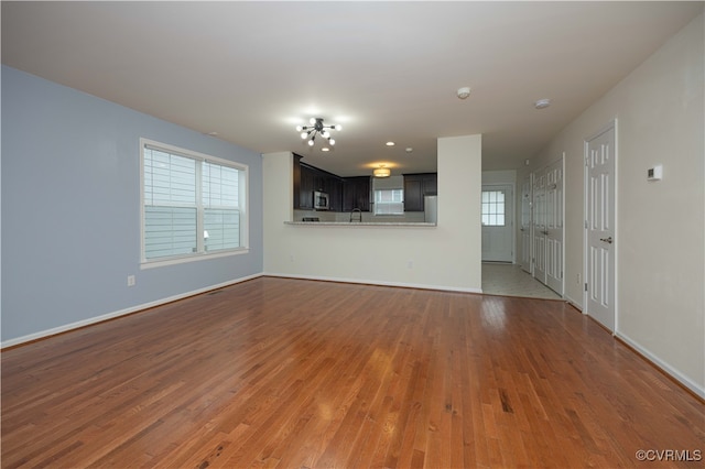 unfurnished living room with hardwood / wood-style flooring and sink