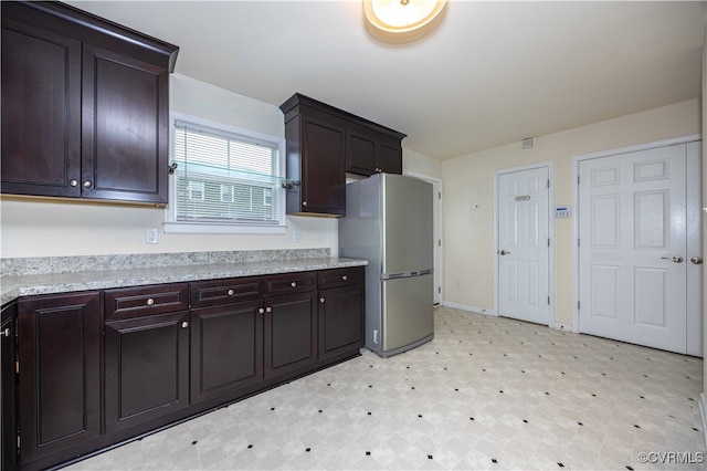 kitchen featuring stainless steel fridge and dark brown cabinets