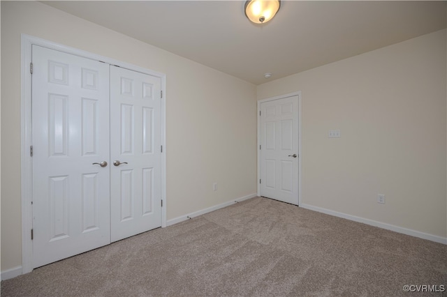 unfurnished bedroom with a closet and light colored carpet