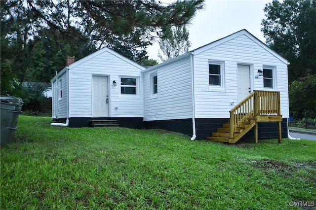 rear view of property featuring a lawn