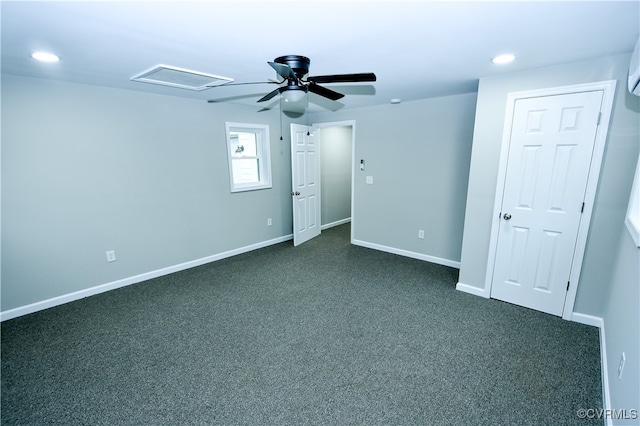 empty room with ceiling fan and dark colored carpet