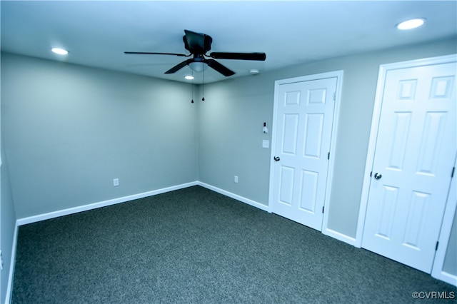 unfurnished room with ceiling fan and dark colored carpet