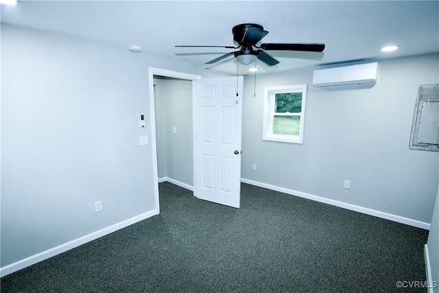 spare room with dark carpet, ceiling fan, and a wall mounted AC