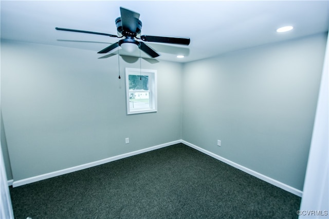 spare room with dark colored carpet and ceiling fan