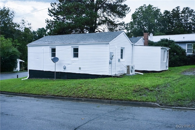 view of home's exterior featuring ac unit and a lawn