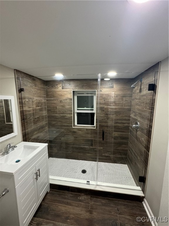 bathroom featuring wood-type flooring, vanity, and a shower with door