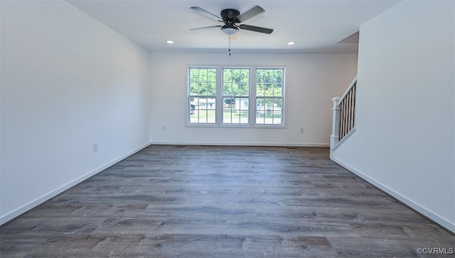 empty room with ceiling fan and dark wood-type flooring