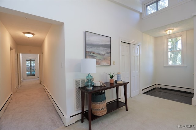 entrance foyer with light carpet and a baseboard radiator