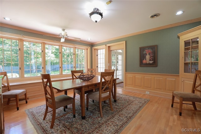 dining room with ceiling fan, light wood-type flooring, and crown molding