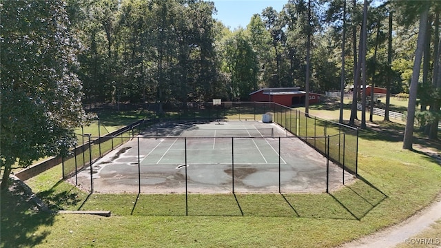 view of tennis court featuring a yard