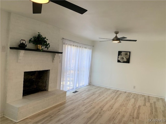 unfurnished living room featuring a fireplace, light wood-type flooring, and ceiling fan