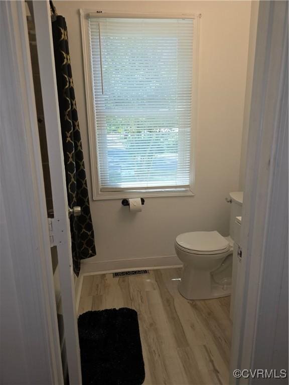 73 Henrico St, Petersburg, VA 23803 - full bathroom with wood finished floors, toilet, a shower with curtain, and baseboards