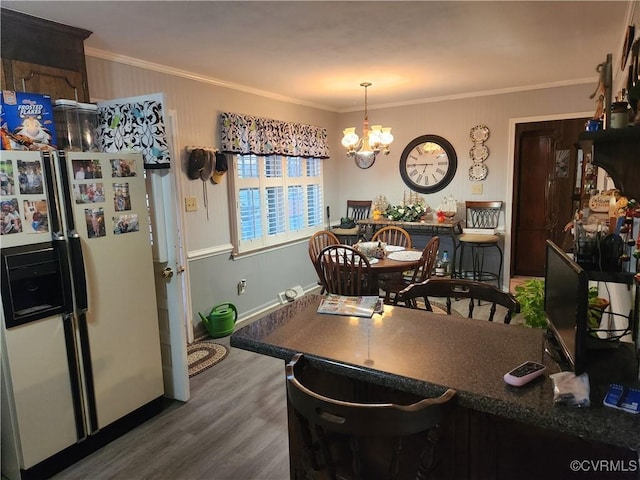 dining area featuring ornamental molding, dark wood-type flooring, a chandelier, and baseboards