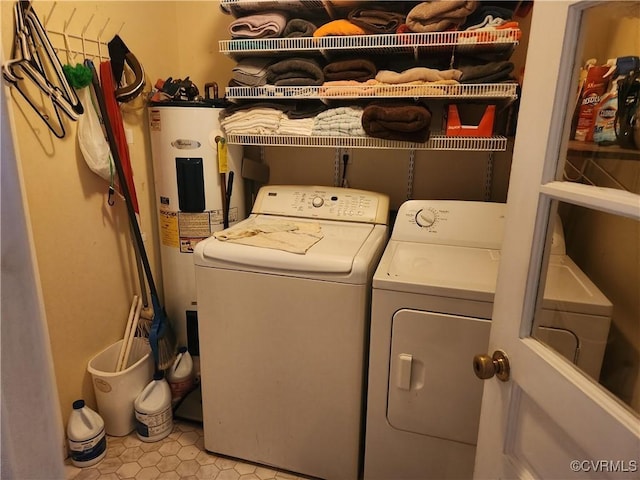 washroom with laundry area, washing machine and dryer, and electric water heater