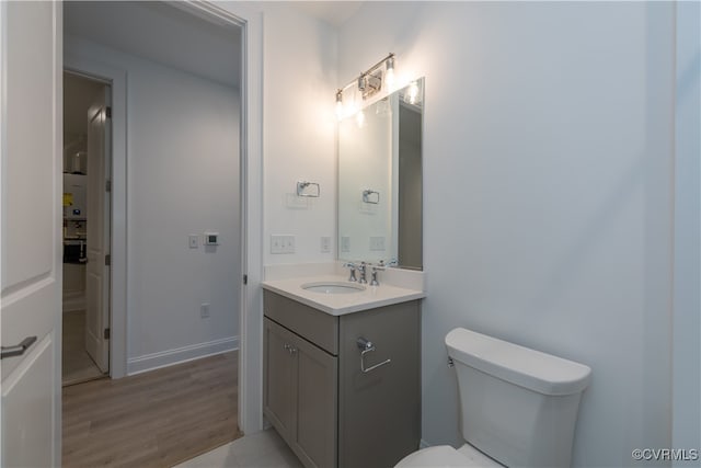 bathroom with toilet, vanity, and hardwood / wood-style flooring