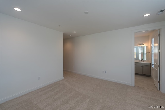 empty room featuring light colored carpet and sink