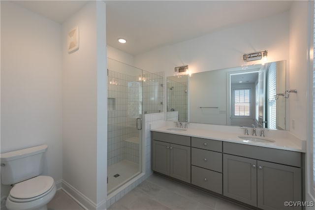 bathroom featuring tile patterned floors, vanity, a shower with shower door, and toilet