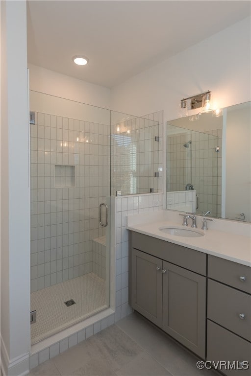 bathroom featuring tile patterned flooring, vanity, and walk in shower