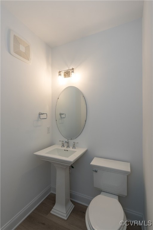 bathroom with toilet and wood-type flooring