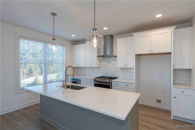 kitchen with stainless steel gas range oven, a wealth of natural light, pendant lighting, and wall chimney range hood