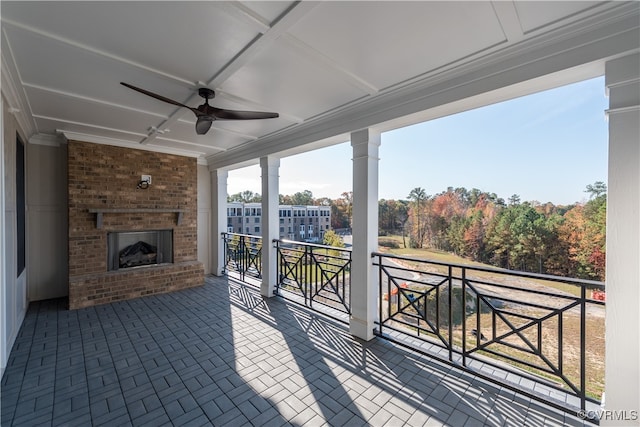 view of patio featuring an outdoor brick fireplace and ceiling fan