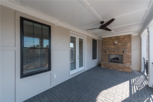 view of patio featuring an outdoor brick fireplace, ceiling fan, and french doors