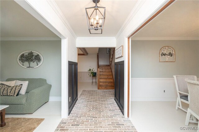 hall with an inviting chandelier and ornamental molding