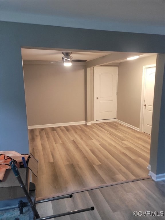 basement featuring ceiling fan and hardwood / wood-style floors