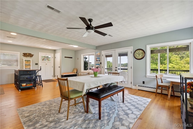 dining space featuring light hardwood / wood-style flooring, a baseboard heating unit, ceiling fan, and plenty of natural light