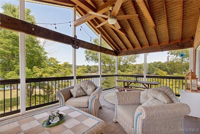 sunroom with wooden ceiling, lofted ceiling with beams, and ceiling fan