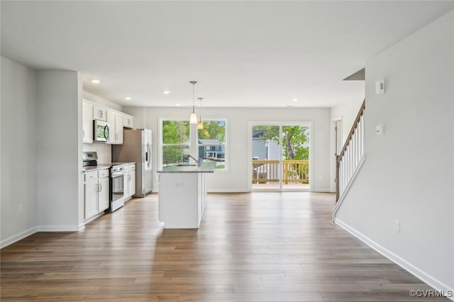 kitchen featuring stainless steel appliances, baseboards, dark wood-style floors, and white cabinetry