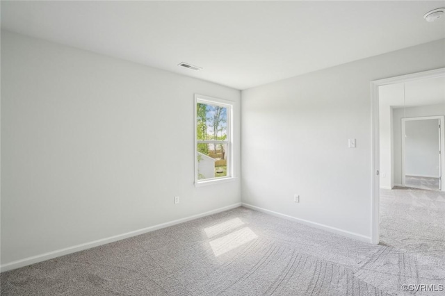 carpeted spare room with baseboards and visible vents