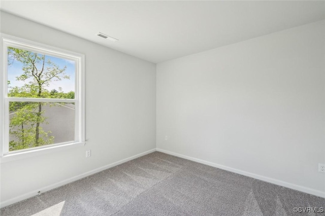 unfurnished room with baseboards, carpet flooring, and visible vents