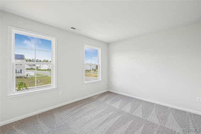 unfurnished room featuring baseboards, visible vents, and carpet floors