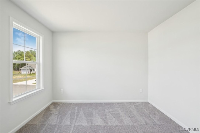 spare room featuring carpet and baseboards