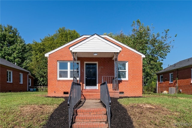 bungalow-style house featuring a front lawn and central AC