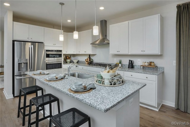 15436 Greenhart Dr, Chesterfield, VA 23832 - kitchen featuring appliances with stainless steel finishes, wall chimney exhaust hood, a sink, light wood-type flooring, and baseboards