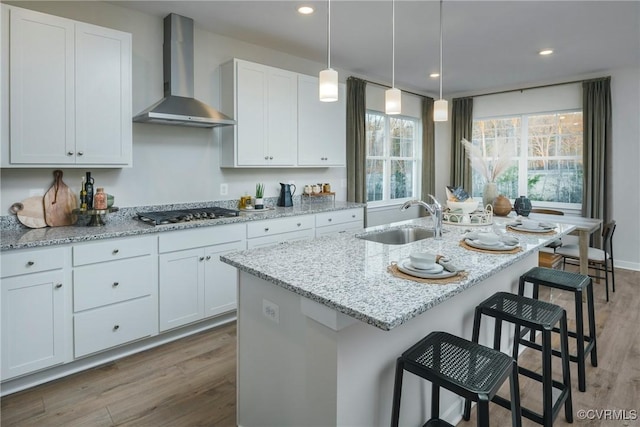 15436 Greenhart Dr, Chesterfield, VA 23832 - kitchen featuring wall chimney exhaust hood, stainless steel gas stovetop, a sink, wood finished floors, and light stone counters