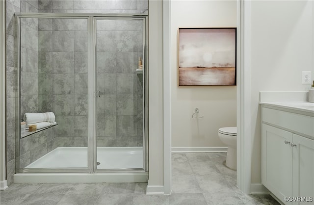 bathroom with a shower with door, vanity, and toilet