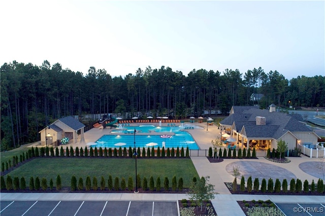 view of pool with a patio area and a lawn