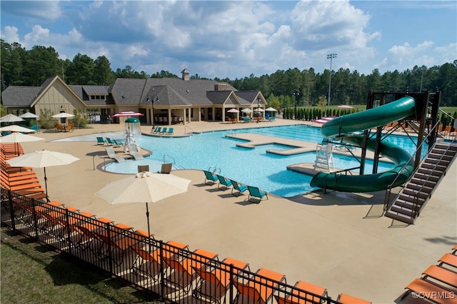 view of pool featuring a water slide and a patio