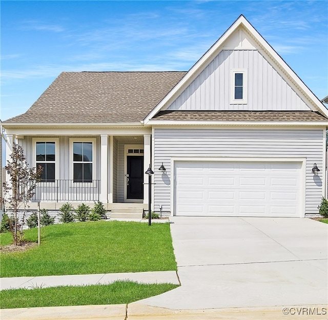 view of front of house featuring a front yard, a garage, and a porch