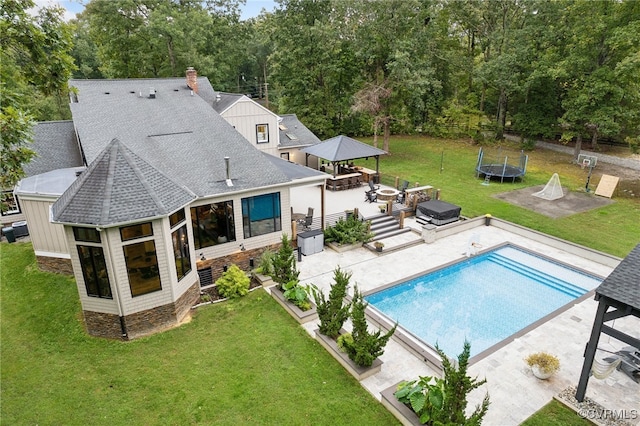 view of swimming pool featuring a patio, area for grilling, a trampoline, and a yard