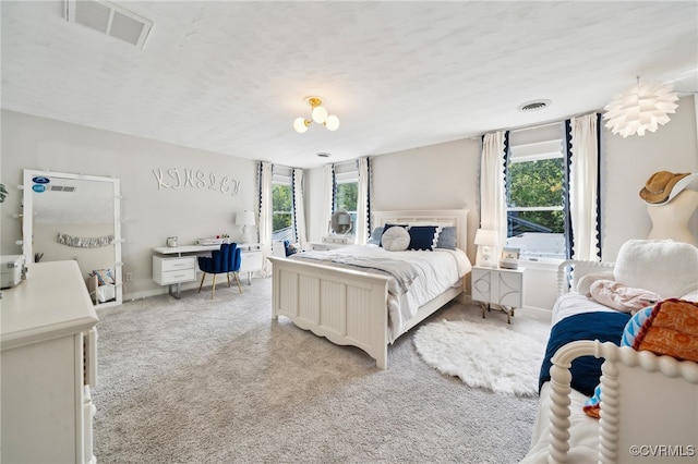 carpeted bedroom featuring a textured ceiling and multiple windows