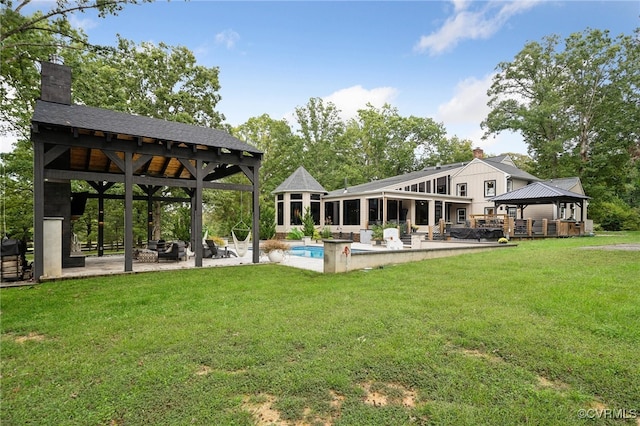 rear view of property featuring a gazebo, a yard, and a patio