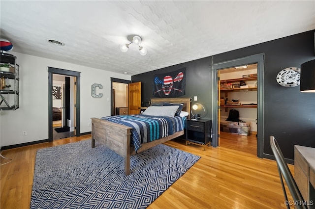 bedroom featuring a closet, a walk in closet, and hardwood / wood-style floors