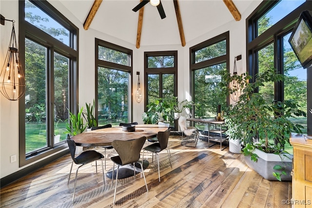 sunroom / solarium featuring ceiling fan, a wealth of natural light, and vaulted ceiling with beams