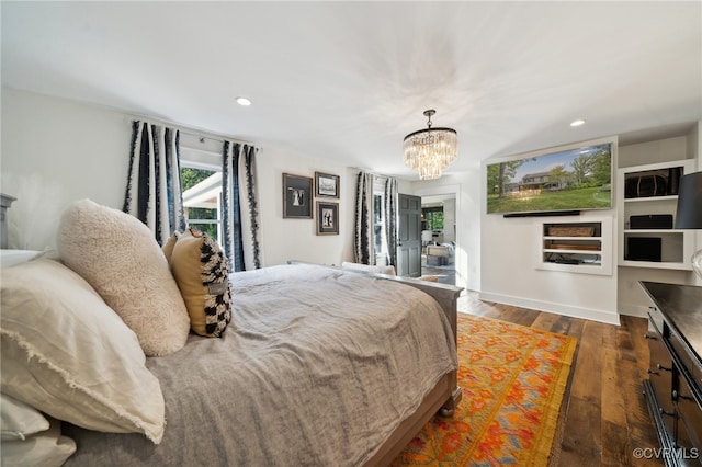 bedroom with an inviting chandelier and dark hardwood / wood-style floors